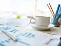 Koffiekopje naast financiële overzichten